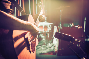 The Studio microphone records an acoustic guitar close-up. Beautiful blurred background of colored...