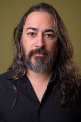 Studio shot of mature handsome bearded multi-ethnic businessman with long hair