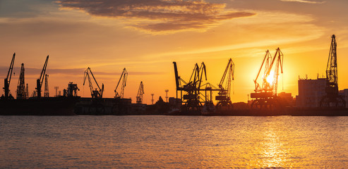 Obraz premium Sunset over sea port and industrial cranes, Varna