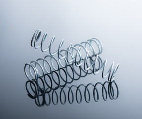 Metal spring on blue background