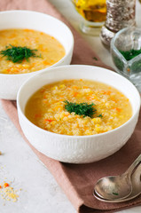 Lentil and bulgur soup puree in a white bowl on a white stone background.