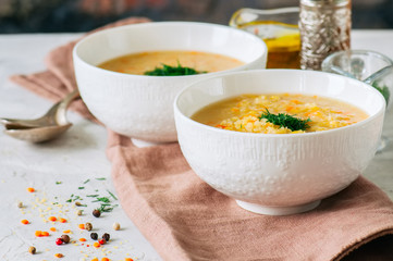 Lentil and bulgur soup puree in a white bowl on a white stone background.