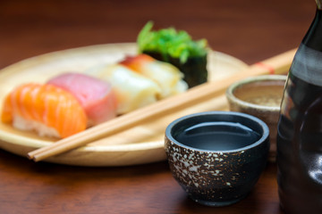 Fototapeta na wymiar sake cup with sushi background