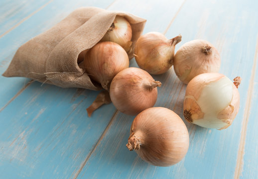 Fresh onions on blue wood table background