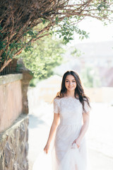 Young pretty girl walking in the streets of the city in a beautiful wedding dress