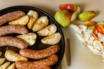 Raw meat sausages with pears and vegitables ready to cook.