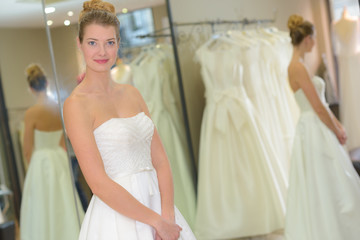 portrait of woman trying on wedding dress in boutique