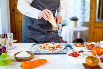 closeup hands of chef making fresh homemade traditional italian pizza. wallpaper for pizzeria and...