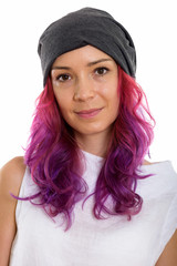 Face of young beautiful woman with pink hair and wearing hat