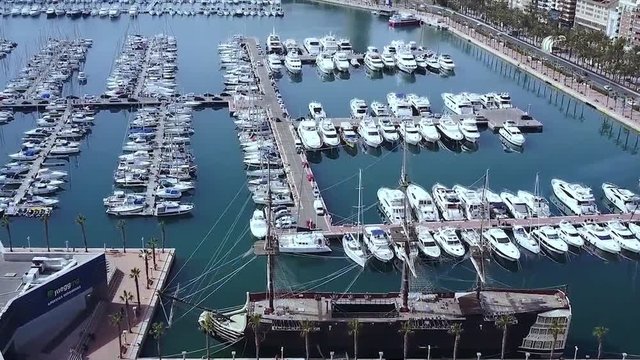 Yacht parking, A marina lot, Yacht and sailboat is moored at the quay, Aerial view of sailing yachts and boats near wooden piers. Stock. Aerial view by drone.