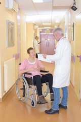 Doctor talking to pregnant woman in wheelchair