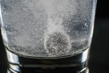 Glass of water and pills isolated on white