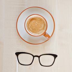 Mustache, glasses and cup of coffee on wooden background. Happy Father's day background