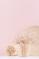 Gentle spring vanilla background with white dry flowers and bamboo dish on light table and pink wall.