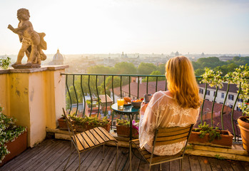 Woman sitting on balcony in early morning © Kaspars Grinvalds
