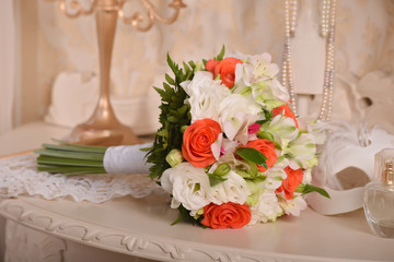 wedding bridal bouquet of orange and white flowers on the boudoir table