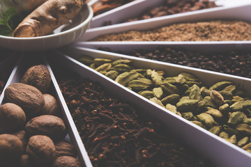 Indian colourful Spices in a white Sunburst or sun rays shape designer container, selective focus.