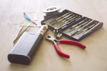 Vaping device mod. In the background a set of tools for servicing electronic cigarettes.