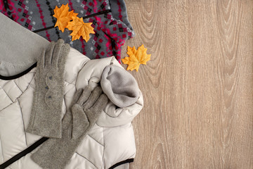 Warm clothes and maple leaves. Autumn clothes in the form of a turtleneck, waistcoat and gloves....
