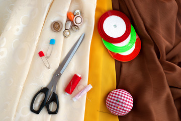 Different silk fabric for sewing. Silk fabric, organza, tailoring scissors, buttons, ribbons and a...