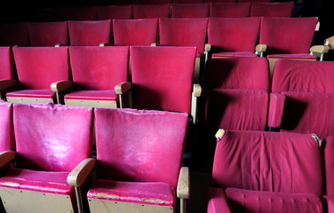 Vieux fauteuils de salle de spectacle en velours rouge. 