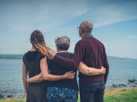 Senior couple with adult daughter by the sea