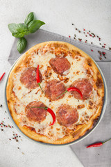 Classic pepperoni Pizza with basil leaves and chili pepper