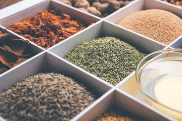 Indian Spices in white wooden box with cells, selective focus.