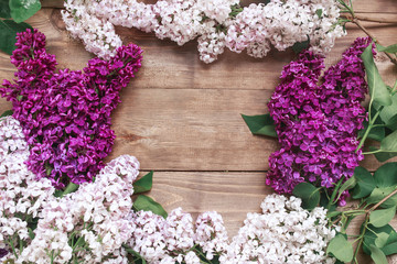 Fototapeta na wymiar Bouquet of purple lilacs flowers on a brown wooden background