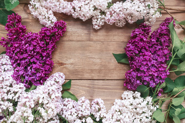 Bouquet of purple lilacs flowers on a brown wooden background