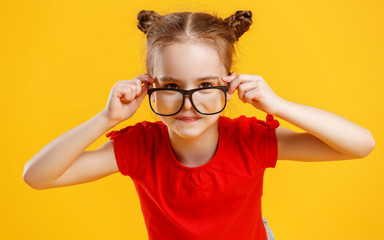 funny child girl in glasses on colored background