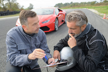 male coach and pilot discussing performance during tests with lamborghini