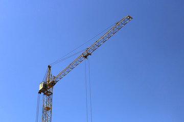 Construction crane against the blue sky.