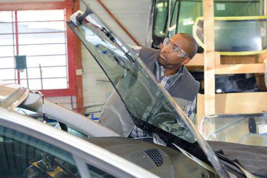 Mechanic fitting new windshield