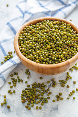 Green mung beans in a wooden bowl.