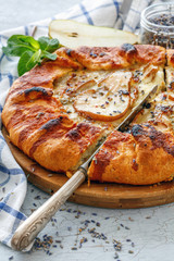 Cut free-form cake (Galette) with pear and lavender.