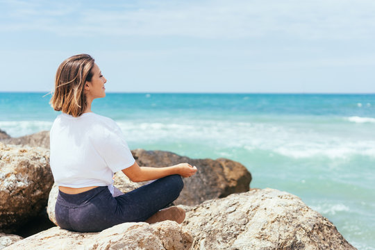 Young woman meditating at the seaside