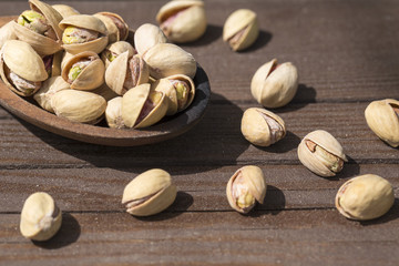 Tasty pistachios in a wooden  background. Salted pistachios