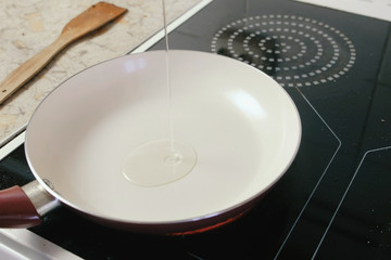 Pour oil on frying pan on electric stove.