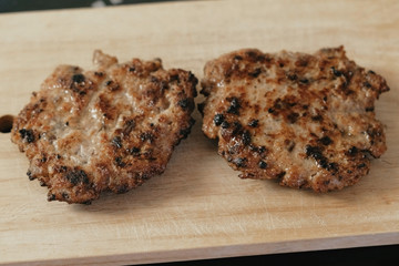Cutlets for burgers on wood board