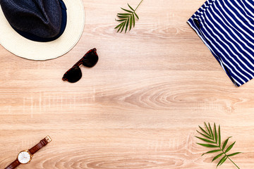 Top view of vacation accessories with copy space and summer beach items. Lay flat fashion background on wooden floor.