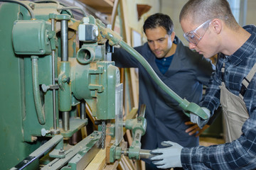 Fototapeta na wymiar engineer and apprentice using machinery in factory