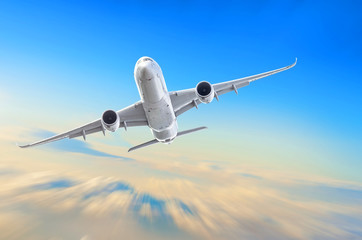 Passenger airplane is climbing high flight level in the sky above the clouds, motion speed blur.