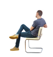 Back view of a man sitting on a chair.