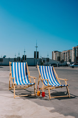 sun loungers with cocktail on parking on sunny summer day