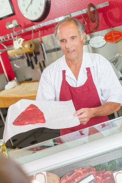 Butcher showing steak to customer