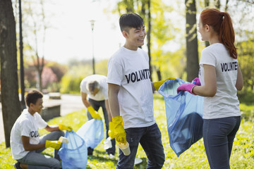 Volunteer for environment. Charming two volunteers holding garbage bag and gazing at each other