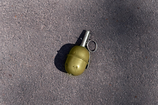 green grenade resting on a battlefield. Hand grenade RGD-5 on asphalt. Lost green garnet. real weapons are dangerous, fragmentation grenade
