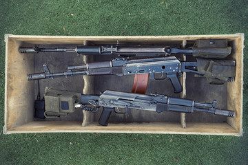 Kalashnikov assault rifles in wooden box. Arms trade. illegal sale of weapons. An automatic weapon...