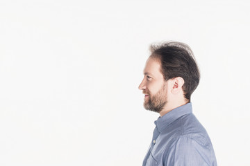 Obraz premium side view of smiling bearded man in shirt isolated on white